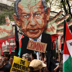 Unos manifestantes sostienen una imagen del primer ministro israelí, Benjamin Netanyahu, con la palabra "Criminal", sobre una multitud que ondea banderas palestinas y porta pancartas con el lema "Palestina libre" durante una manifestación celebrada el día de su discurso ante la 81.ª Asamblea General de las Naciones Unidas en Nueva York. | Foto:CHARLY TRIBALLEAU / AFP