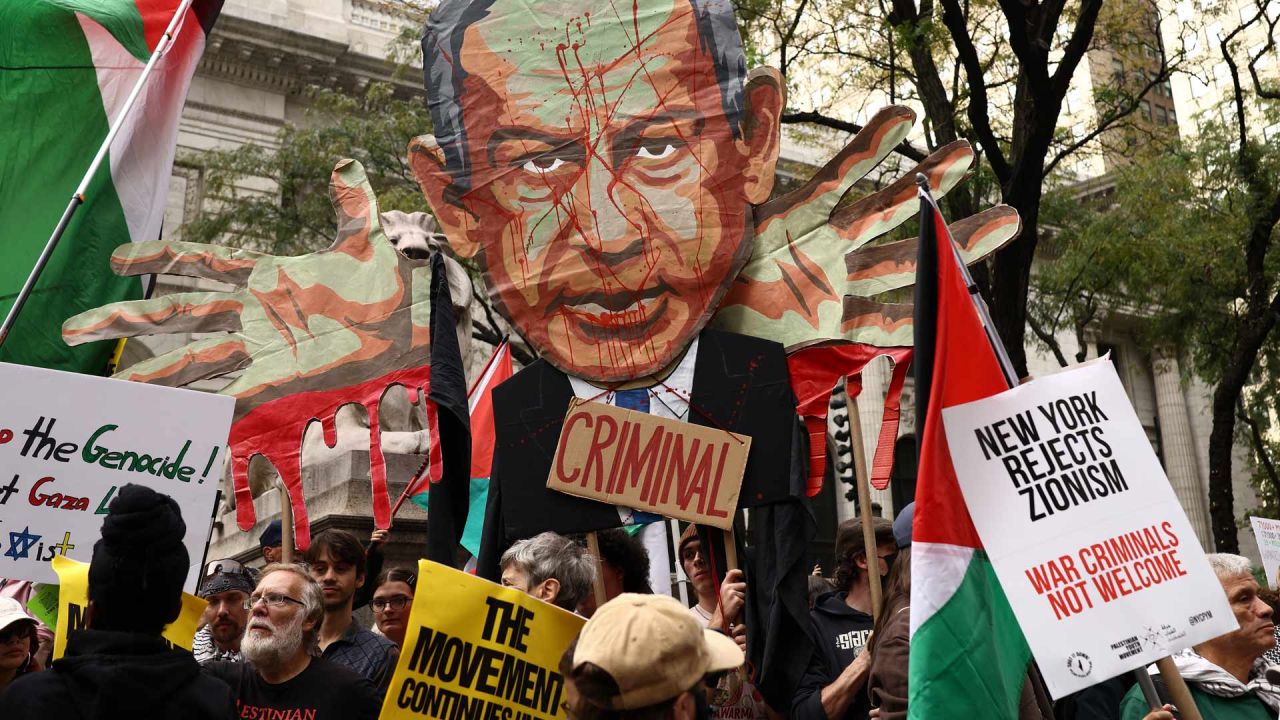 Unos manifestantes sostienen una imagen del primer ministro israelí, Benjamin Netanyahu, con la palabra "Criminal", sobre una multitud que ondea banderas palestinas y porta pancartas con el lema "Palestina libre" durante una manifestación celebrada el día de su discurso ante la 81.ª Asamblea General de las Naciones Unidas en Nueva York. | Foto:CHARLY TRIBALLEAU / AFP