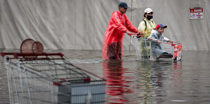 Una familia avanza con un carro a través de las aguas de la inundación en el distrito de Bang Kapi, en Bangkok. Miles de residentes de Bangkok amanecieron en refugios después de que las inundaciones, provocadas por días de fuertes lluvias en la capital tailandesa, anegaran viviendas y carreteras; algunos ya han comenzado a secar sus hogares y pertenencias.