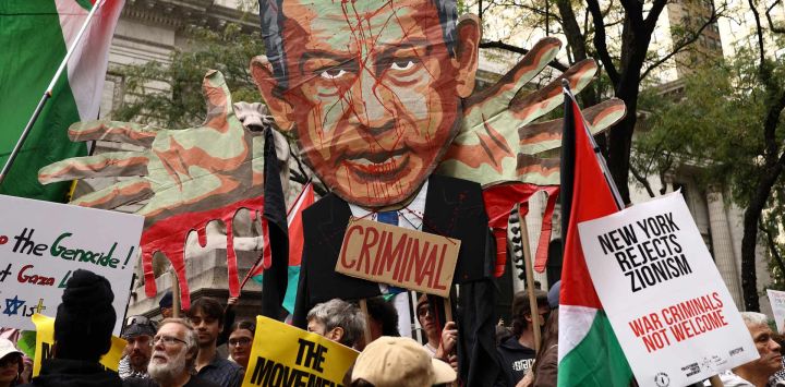 Unos manifestantes sostienen una imagen del primer ministro israelí, Benjamin Netanyahu, con la palabra "Criminal", sobre una multitud que ondea banderas palestinas y porta pancartas con el lema "Palestina libre" durante una manifestación celebrada el día de su discurso ante la 81.ª Asamblea General de las Naciones Unidas en Nueva York.
