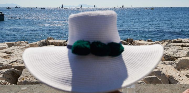 Una mujer observa la regata final de la competición preliminar de la 38.ª Copa América Louis Vuitton en Nápoles.