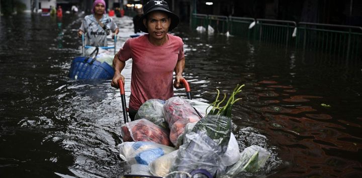 Vendedores transportan productos agrícolas a través de aguas inundadas en el distrito de Bang Kapi, Bangkok. Ocho personas han fallecido debido a las inundaciones en Tailandia aunque ninguna en la capital, Bangkok, que declaró el estado de desastre este fin de semana tras las fuertes lluvias.