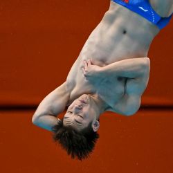 El chino Zheng Jiuyuan compite en la final de saltos de trampolín de 3 metros masculino durante los Juegos Asiáticos de 2026, en el Centro Acuático de Tokio. | Foto:ANDREW CABALLERO-REYNOLDS / AFP