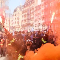 Un manifestante sostiene bengalas encendidas durante una protesta de bomberos convocada por una amplia coalición de sindicatos que reclaman mejores salarios y mayores recursos presupuestarios, en París. Los bomberos profesionales —empleados de las administraciones locales—, junto con unos 200.000 bomberos voluntarios, exigen un aumento de las contrataciones, mayores medidas de protección de la salud y un enfoque más claro en sus funciones principales. | Foto:XAVIER GALIANA / AFP
