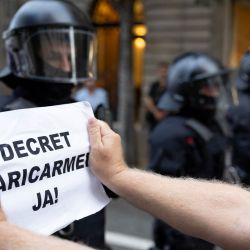 Un manifestante sostiene un cartel con el lema "¡Decreto Maricarmen ya!" frente a las fuerzas policiales durante una protesta con motivo de la visita del presidente del Gobierno español, en plena crisis de la vivienda en España, en Barcelona (Cataluña). Se espera que el gobierno del presidente socialista apruebe un paquete de medidas denominado "decreto Maricarmen", tras el desahucio la semana pasada de Maricarmen Abascal, una mujer de 87 años, de la que había sido su vivienda de toda la vida. Según se ha informado, la medida incluirá la renovación automática de los contratos de alquiler y mayores restricciones a los desahucios. | Foto:Josep Lago / AFP