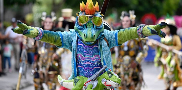 Un bailarín disfrazado de T-Rex actúa durante un "Convite", un festival de danza tradicional, en Ciudad de Guatemala.