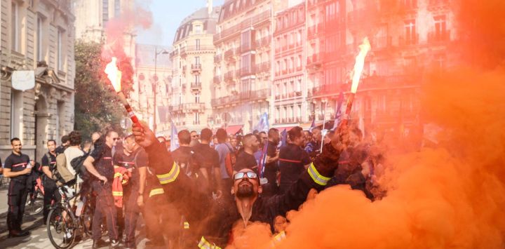 Un manifestante sostiene bengalas encendidas durante una protesta de bomberos convocada por una amplia coalición de sindicatos que reclaman mejores salarios y mayores recursos presupuestarios, en París. Los bomberos profesionales —empleados de las administraciones locales—, junto con unos 200.000 bomberos voluntarios, exigen un aumento de las contrataciones, mayores medidas de protección de la salud y un enfoque más claro en sus funciones principales.