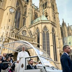 El papa León XIV llega en el papamóvil para celebrar una misa en la catedral de Saint-Étienne de Metz, en Metz (noreste de Francia), en el último día de su visita a Francia. | Foto:ALBERTO PIZZOLI / AFP