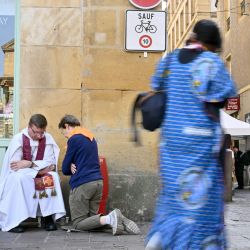 Una persona se confiesa con un sacerdote en una calle de Metz, en el noreste de Francia, cerca de la catedral de San Esteban, donde el Papa oficiará una misa más tarde, en el último día de su visita a Francia. | Foto:SEBASTIEN BOZON / AFP