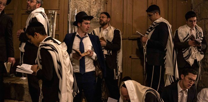 Hombres judíos ortodoxos rezan frente a la puerta de Bab al-Qattanin (de los Mercaderes de Algodón) del recinto de Al-Aqsa durante las oraciones matutinas de Sucot —la Fiesta de las Cabañas— en la Ciudad Vieja de Jerusalén. Cada año, miles de judíos peregrinan a Jerusalén durante la festividad de la cosecha de Sucot, que dura una semana y conmemora, según la tradición judía, el peregrinaje de los israelitas por el desierto tras el éxodo bíblico.