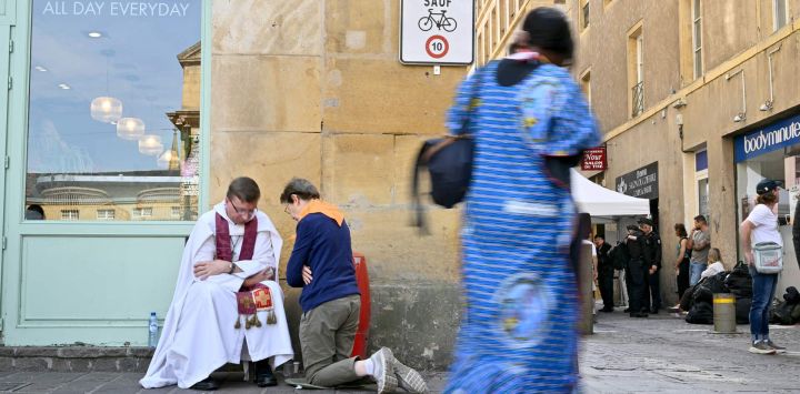 Una persona se confiesa con un sacerdote en una calle de Metz, en el noreste de Francia, cerca de la catedral de San Esteban, donde el Papa oficiará una misa más tarde, en el último día de su visita a Francia.
