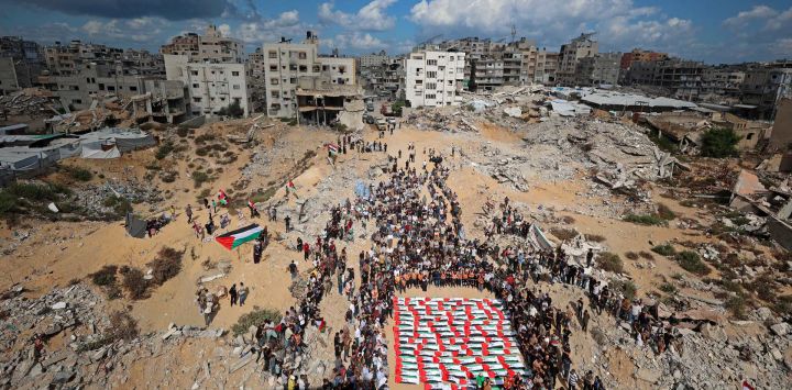Palestinos se reúnen para una procesión funeraria colectiva en el barrio de Al-Yarmouk, en Gaza, tras la recuperación de 105 cuerpos de entre los escombros del complejo residencial Al-Taj, destruido por ataques israelíes.