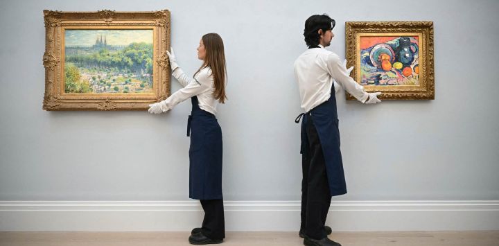 Miembros del personal muestran "Le Jardin des Tuileries" (izq.), del pintor francés Claude Monet, y "Nature morte à la cruche bleue" (der.) (Bodegón con jarra azul), del pintor francés Maurice de Vlaminck, durante una presentación para los medios organizada por la casa de subastas Sotheby's sobre "El Eldorado de las colecciones de arte", que incluye 12 pinturas que llevaban mucho tiempo sin verse en público y están valoradas en 450 millones de dólares, en el centro de Londres.