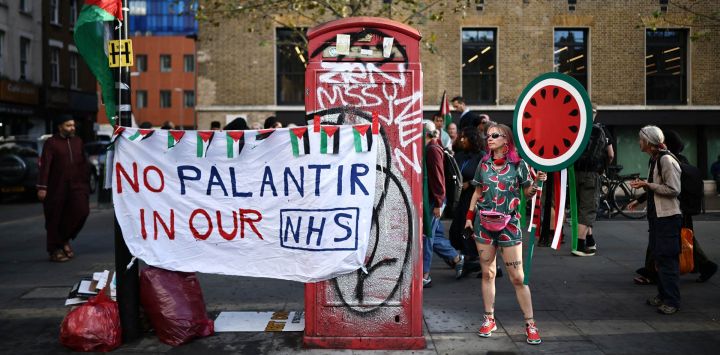 Personas participan en una protesta contra la empresa tecnológica estadounidense Palantir en Whitechapel, en el centro de Londres, para instar al gobierno británico a hacer uso de una cláusula de rescisión que impediría la renovación, más allá de marzo de 2027, del contrato entre el gigante de la inteligencia artificial y el Servicio Nacional de Salud (NHS). El gobierno del Reino Unido se enfrenta a una presión creciente para poner fin a un contrato de 330 millones de libras esterlinas (438 millones de dólares) entre el NHS y Palantir, ante las advertencias de médicos, legisladores y activistas sobre los riesgos éticos que conlleva.