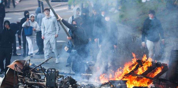 Un manifestante arroja una señal de "Stop" a una hoguera mientras estudiantes llevan a cabo un bloqueo cerca del instituto Kerichen en Brest, en el oeste de Francia. Desde finales de septiembre, los estudiantes han protagonizado protestas frente a los centros educativos por diversas quejas, que van desde los horarios, el tamaño de las clases y la falta de profesores hasta el calor excesivo en las aulas durante las olas de calor de este año. Las protestas comenzaron en la región de Île-de-France, en los alrededores de París, pero se han extendido a otras ciudades de todo el país.