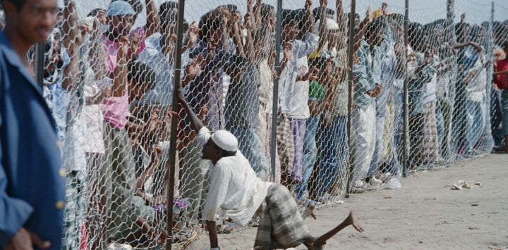 Un refugiado somalí que padece hambre y llegó con anterioridad observa a unas 2.500 personas más que arribaron a Adén, tras una travesía oceánica a bordo del carguero *Summai* para escapar de la guerra y la hambruna en Somalia.