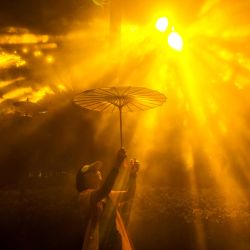 Una mujer que sostiene un paraguas posa para una fotografía mientras visita el Festival Internacional de la Luz de Shanghái, en un parque de la ciudad. | Foto:CN-STR / AFP