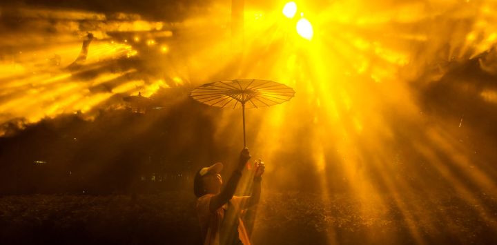 Una mujer que sostiene un paraguas posa para una fotografía mientras visita el Festival Internacional de la Luz de Shanghái, en un parque de la ciudad.