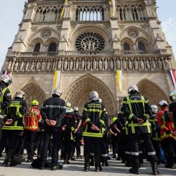 Bomberos guardan un minuto de silencio en memoria de sus compañeros fallecidos mientras combatían incendios forestales en Francia, frente a la catedral de Notre-Dame de París, durante una protesta convocada por una amplia coalición de sindicatos que reclaman mejores salarios y mayores recursos presupuestarios, en París. | Foto:XAVIER GALIANA / AFP