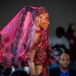 Unas modelos presentan una creación de Wosstika's Design durante la Semana de la Moda de Nigeria 2026, celebrada en el Soul Lounge Resort de Abuya. Las modelos nigerianas lucieron atuendos que incorporaban cantidades de tela aparentemente imposibles, plegadas y moldeadas para formar siluetas voluminosas o superpuestas en patrones que recordaban a las escamas o a las plumas. | Foto:Light Oriye Tamunotonye / AFP