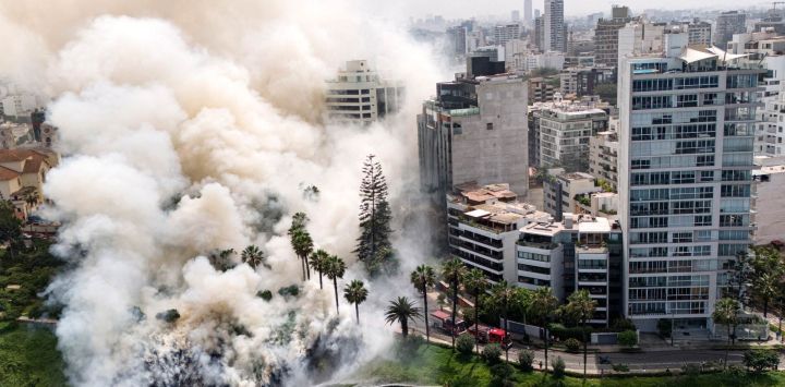 Esta vista aérea muestra el humo que se eleva de un incendio en los acantilados de la Costa Verde, en el distrito limeño de Miraflores, Perú.