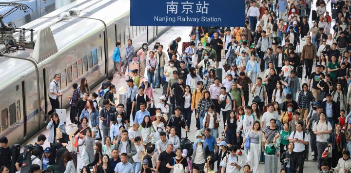 Pasajeros salen de la Estación del Ferrocarril de Nanjing, en Nanjing, en la provincia de Jiangsu, en el este de China. La red de transporte del país marcó un pico de viajes en el primer día de las vacaciones del Día Nacional.