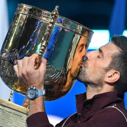 El serbio Novak Djokovic besa el trofeo mientras celebra su victoria en la final individual masculina contra el australiano Alex de Minaur en el torneo de tenis China Open, en Pekín. | Foto:Greg Baker / AFP