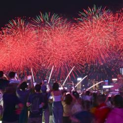 Turistas observan el espectáculo de fuegos artificiales en la celebración del 77º aniversario de la fundación de la República Popular China, en Hong Kong, en el sur de China. Personas de toda China salieron a disfrutar plenamente de su tiempo libre durante las vacaciones del Día Nacional. | Foto:Xinhua/Chen Duo