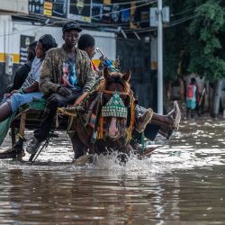 Un carro tirado por caballos transporta pasajeros por una calle inundada en Dakar. Las fuertes lluvias anegaron zonas de Senegal; el presidente Bassirou Diomaye Faye declaró que había recibido "con profunda tristeza" la noticia de las muertes causadas por los aguaceros. Faye añadió que el gobierno estaba "plenamente movilizado" y reforzaría la vigilancia en las zonas vulnerables. | Foto:SEYLLOU / AFP