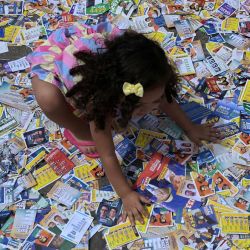 Una niña juega con folletos políticos en la favela Cidade de Deus, en el suroeste de Río de Janeiro (Brasil), el día de las elecciones presidenciales. | Foto:TERCIO TEIXEIRA / AFP