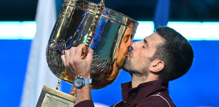 El serbio Novak Djokovic besa el trofeo mientras celebra su victoria en la final individual masculina contra el australiano Alex de Minaur en el torneo de tenis China Open, en Pekín.