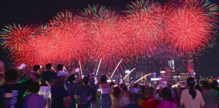 Turistas observan el espectáculo de fuegos artificiales en la celebración del 77º aniversario de la fundación de la República Popular China, en Hong Kong, en el sur de China. Personas de toda China salieron a disfrutar plenamente de su tiempo libre durante las vacaciones del Día Nacional.
