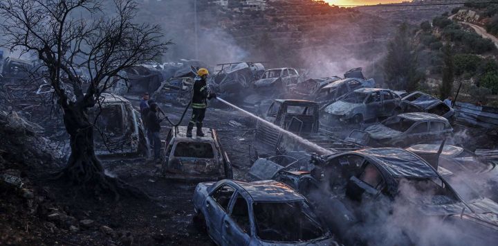 Un bombero de la defensa civil palestina sofoca un incendio que calcinó automóviles y olivos en un depósito de chatarra tras un ataque presuntamente perpetrado por colonos israelíes en la localidad de Ayn Yabrud, al noreste de Ramala, en Cisjordania (territorio ocupado por Israel). La violencia se ha intensificado paralelamente a la ofensiva de Israel en Gaza, iniciada en respuesta al ataque masivo de Hamás del 7 de octubre de 2023. Según las Naciones Unidas, los ataques de colonos israelíes contra palestinos —que incluyen agresiones físicas, actos de vandalismo e incendios provocados— registraron una media de seis incidentes diarios durante la primera mitad del año, mientras Israel se enfrenta a crecientes críticas internacionales por el aumento de la violencia ejercida por los colonos.