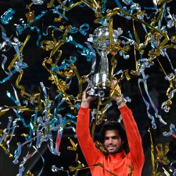 El español Carlos Alcaraz sostiene el trofeo mientras celebra su victoria sobre el checo Jiri Lehecka en la final individual masculina del torneo de tenis Abierto de Japón, en el Ariake Tennis Forest Park de Tokio. | Foto:RIE KIKUCHI / AFP