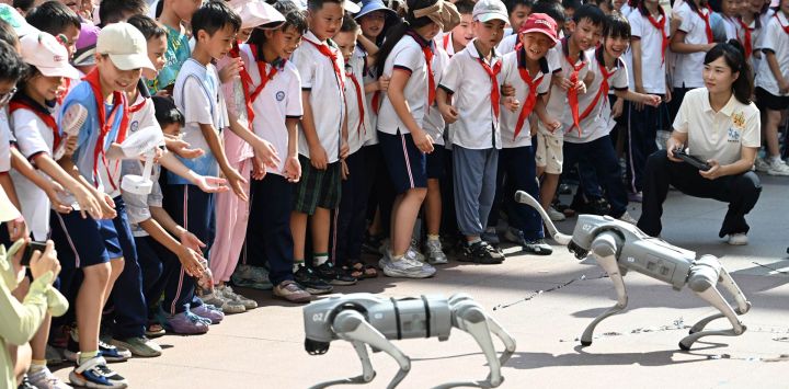 Imagen de estudiantes observando una presentación de perros robot durante un festival de ciencias en una escuela primaria, en Wuzhou, en la región autónoma zhuang de Guangxi, en el sur de China.
