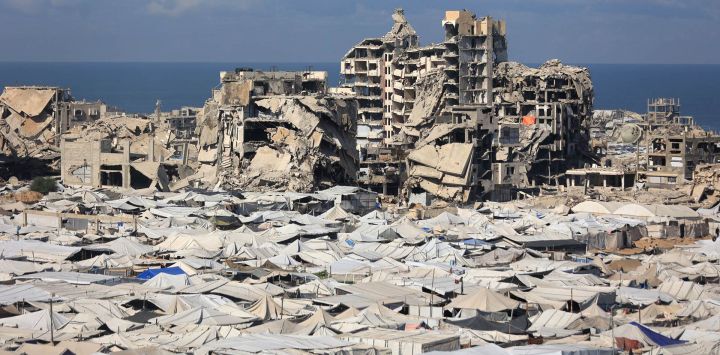 Se observa una vista de las tiendas de campaña provisionales de palestinos desplazados junto a edificios destruidos en la ciudad de Gaza.