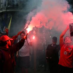 Estudiantes que apoyan al presidente de Brasil y candidato presidencial Luiz Inácio Lula da Silva para la segunda vuelta electoral encienden bengalas mientras sostienen una imagen del candidato derechista Flavio Bolsonaro caracterizado como Adolf Hitler, durante una marcha contra la extrema derecha en Río de Janeiro, Brasil. Lula da Silva, quien ha resurgido de las cenizas políticas en varias ocasiones, se dirige a una segunda vuelta electoral contra el senador derechista Flavio Bolsonaro el 25 de octubre, tras quedar sorpresivamente en segundo lugar en la primera ronda de votación. | Foto:PABLO PORCIUNCULA / AFP