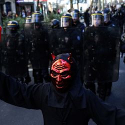 Un manifestante disfrazado de diablo camina frente a agentes de las Compañías Republicanas de Seguridad (CRS) de Francia durante una manifestación de estudiantes de secundaria en París, en el marco de un movimiento de protesta nacional por las condiciones de enseñanza. Desde finales de septiembre, los alumnos han bloqueado las entradas de cientos de centros educativos para denunciar la ausencia de profesores, los horarios sobrecargados, el deterioro de las aulas y la falta de adaptación de los edificios a las temperaturas crecientes, entre otras reivindicaciones. | Foto:KENZO TRIBOUILLARD / AFP