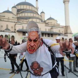 Un manifestante lleva una máscara que representa al primer ministro israelí, Benjamin Netanyahu, durante una marcha propalestina en Ankara. | Foto:ADEM ALTAN / AFP