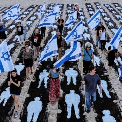 Una vista aérea muestra a personas portando banderas de Israel mientras caminan por una instalación conmemorativa montada en la playa de Tel Aviv para recordar el tercer aniversario del ataque de Hamás contra Israel. | Foto:JACK GUEZ / AFP