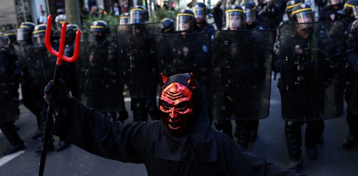 Un manifestante disfrazado de diablo camina frente a agentes de las Compañías Republicanas de Seguridad (CRS) de Francia durante una manifestación de estudiantes de secundaria en París, en el marco de un movimiento de protesta nacional por las condiciones de enseñanza. Desde finales de septiembre, los alumnos han bloqueado las entradas de cientos de centros educativos para denunciar la ausencia de profesores, los horarios sobrecargados, el deterioro de las aulas y la falta de adaptación de los edificios a las temperaturas crecientes, entre otras reivindicaciones.