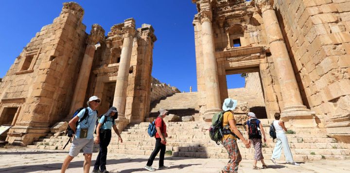 Imagen de turistas visitando un sitio arqueológico romano, en Jerash, Jordania.