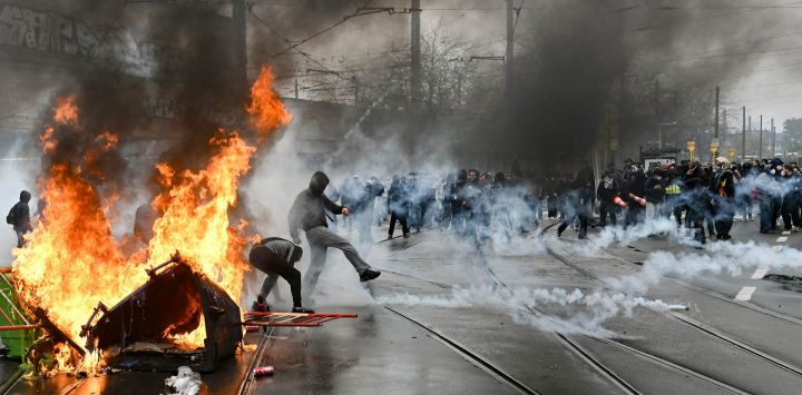 Un manifestante devuelve de una patada un bote de gas lacrimógeno durante una protesta sindical contra las medidas presupuestarias del Gobierno federal, cerca de la estación de tren Bruselas-Sur. Trabajadores belgas y estudiantes de secundaria se unieron para salir a las calles ese día en una nueva huelga nacional contra las medidas de austeridad del Gobierno. La manifestación, que se esperaba congregara a miles de personas en Bruselas, se produce en un clima de gran tensión, después de que las protestas estudiantiles —inspiradas en las que tienen lugar en Francia— derivaran en violencia esta semana.