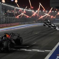 El piloto neerlandés de Red Bull Racing, Max Verstappen, cruza la línea de meta bajo la bandera a cuadros para ganar el Gran Premio de Singapur de Fórmula 1 en el circuito urbano de Marina Bay, Singapur. | Foto:Ng Han Guan / POOL / AFP