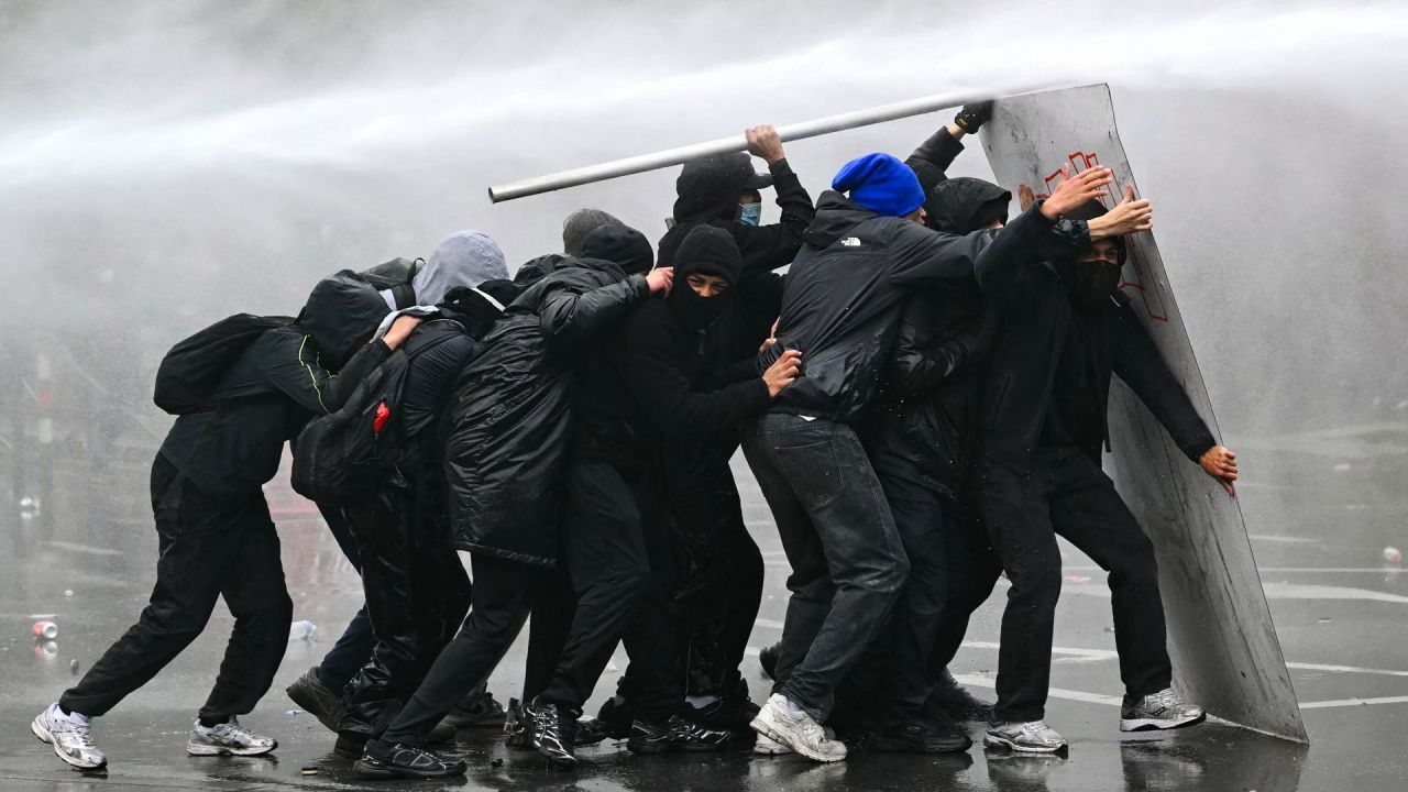 Un cañón de agua rocía a los manifestantes durante una protesta sindical contra las medidas presupuestarias del Gobierno federal, cerca de la estación de tren Bruselas-Sur. Trabajadores belgas y estudiantes de secundaria salieron a las calles ese mismo día para participar en una nueva huelga nacional contra las medidas de austeridad gubernamentales. La manifestación, que se esperaba congregara a miles de personas en Bruselas, se produce en un clima de gran tensión, después de las protestas estudiantiles —inspiradas en las que tienen lugar en Francia— derivaran en actos violentos. | Foto:NICOLAS TUCAT / AFP
