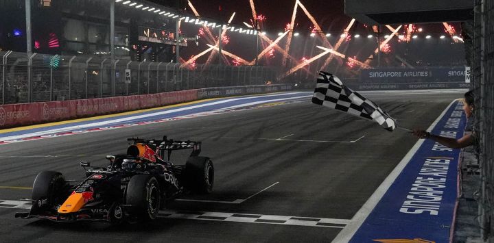 El piloto neerlandés de Red Bull Racing, Max Verstappen, cruza la línea de meta bajo la bandera a cuadros para ganar el Gran Premio de Singapur de Fórmula 1 en el circuito urbano de Marina Bay, Singapur.