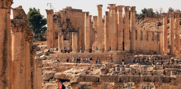 Imagen de turistas visitando un sitio arqueológico romano, en Jerash, Jordania.