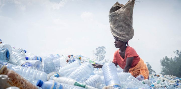 Kwizerimana Mateso lleva un saco sobre la cabeza mientras clasifica montones de botellas de plástico desechadas en el vertedero de Mubone, en el distrito de Buterere (Buyumbura). En el vertedero de Mubone —el principal depósito de residuos que abastece a Buyumbura, la capital comercial de Burundi—, cientos de mujeres pasan el día buscando fragmentos de carbón y materiales reciclables para venderlos en los mercados locales. Muchas de ellas son el único sustento de sus hogares y ganan unos 2.000 francos burundeses (aproximadamente 0,70 dólares) al día para mantener a sus familias, en un contexto donde la grave inflación y la escasez nacional de combustible impulsan la demanda de energía doméstica más económica.