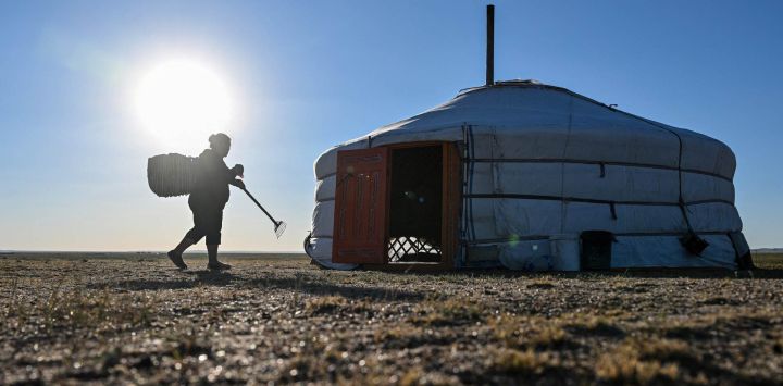 En esta fotografía la pastora Ganchimeg llega a su tradicional tienda *ger* en Bayantal, en la provincia mongola de Govisumber. Mongolia se ve afectada de manera desproporcionada por el cambio climático provocado por el ser humano —fenómeno que, según los científicos, se intensifica a nivel mundial—, lo que amenaza a la población nómada del país y a su ganado.
