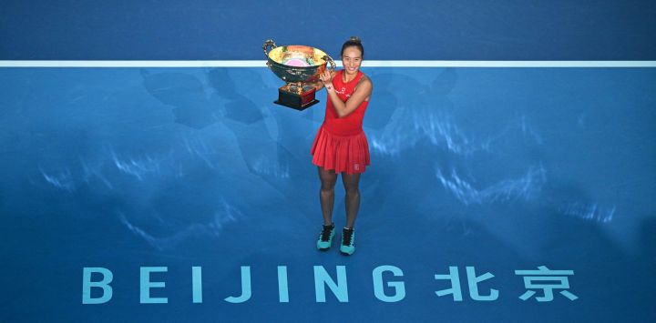La china Zheng Qinwen celebra con el trofeo tras vencer a la rusa Mirra Andreeva en la final individual femenina del torneo de tenis China Open en Pekín.